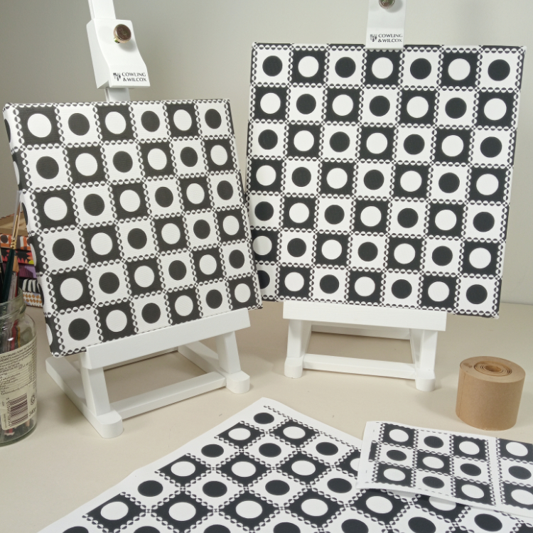 Photograph of two canvas prints with Domino design in black and white on easels
